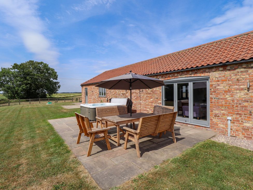 An outdoor dining area with a table and chairs at The Stables in Wrangle near Old Leake