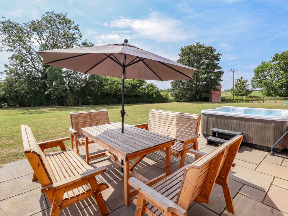 A dining area with a table and chairs and a hot tub at The Stables Wrangle near Old Leake
