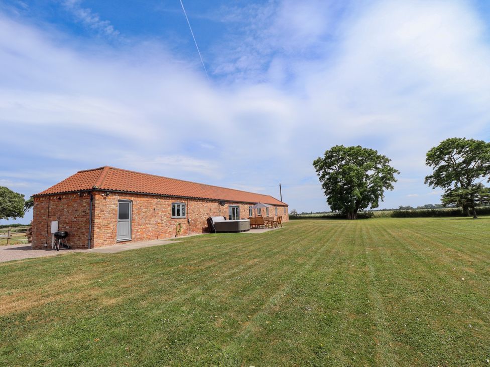 An outdoor area with a brick building and furniture at The Stables in Wrangle near Old Leake