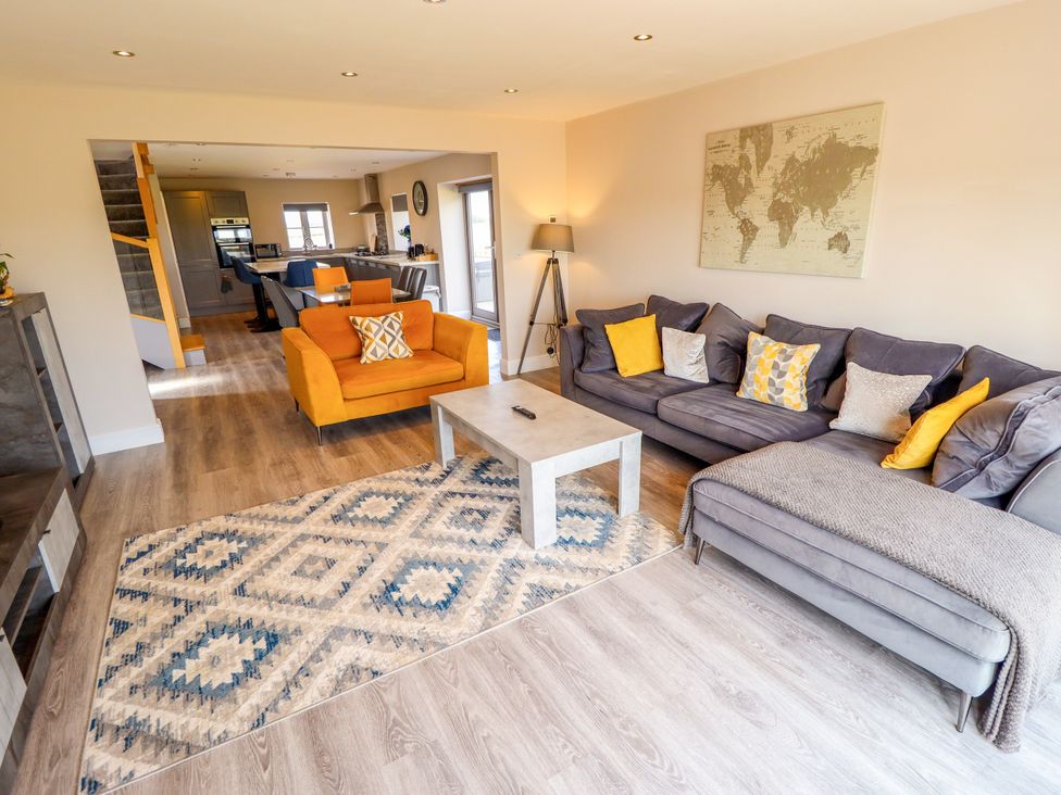 A living room with a sofa, armchair, and coffee table at Acacia Barn Wrangle near Friskney