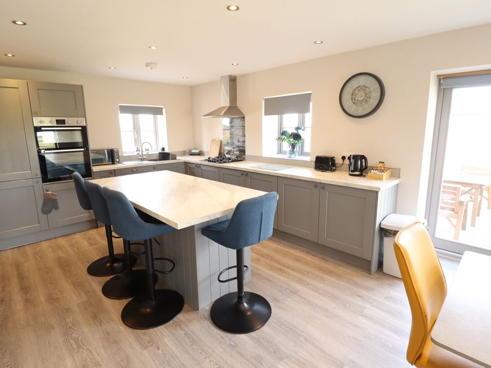 A kitchen with bar stools and appliances at Acacia Barn Wrangle near Friskney