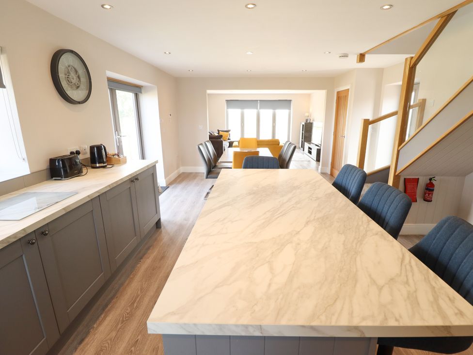 A kitchen with a marble countertop and dining chairs at Acacia Barn Wrangle near Friskney