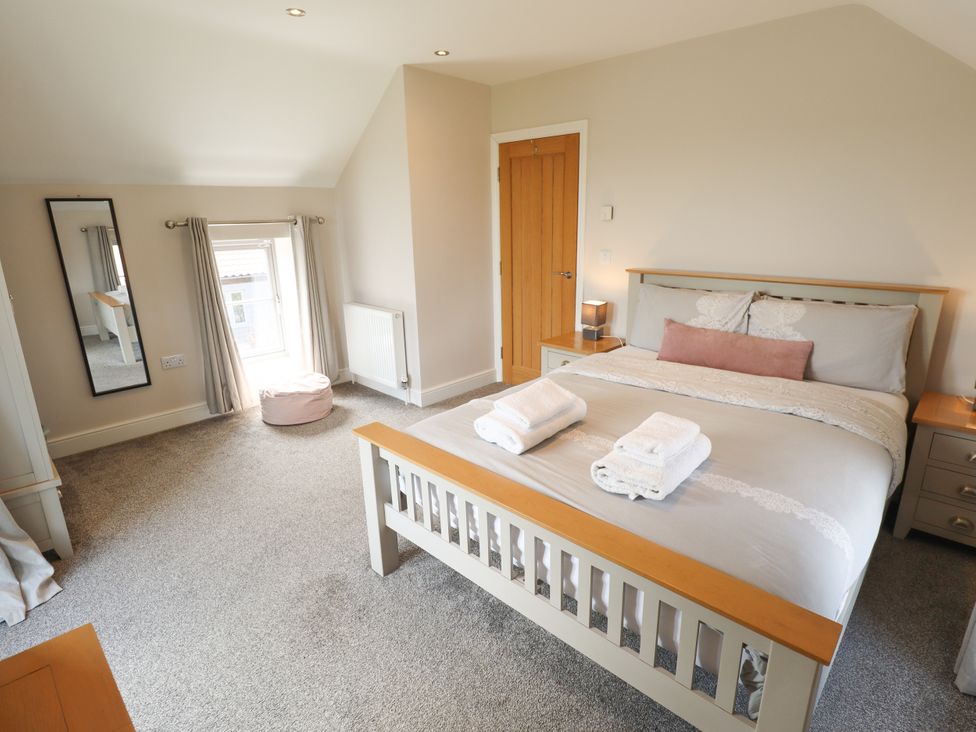 A bedroom with a bed and a mirror at Acacia Barn in Wrangle near Friskney