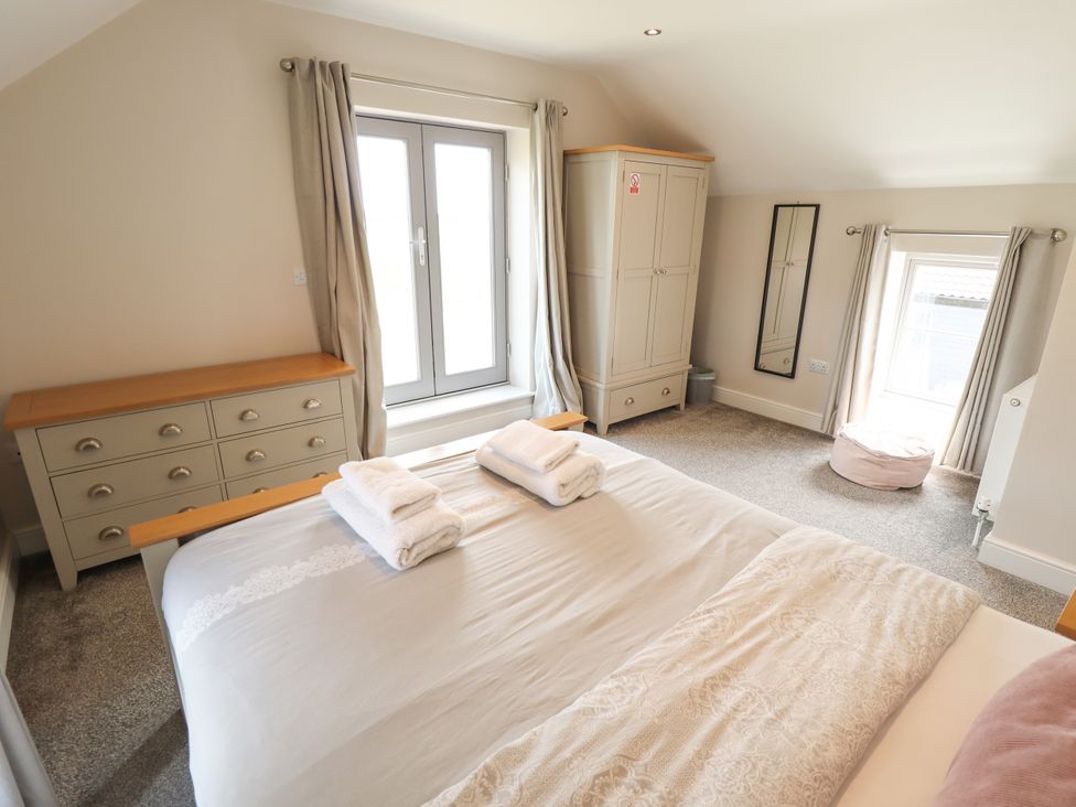A bedroom with a bed and window at Acacia Barn in Wrangle near Friskney