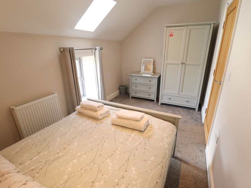 A bedroom with a bed and wardrobe at Acacia Barn in Wrangle near Friskney