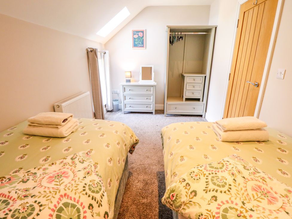 A bedroom with two beds and a dresser at Acacia Barn in Wrangle near Friskney