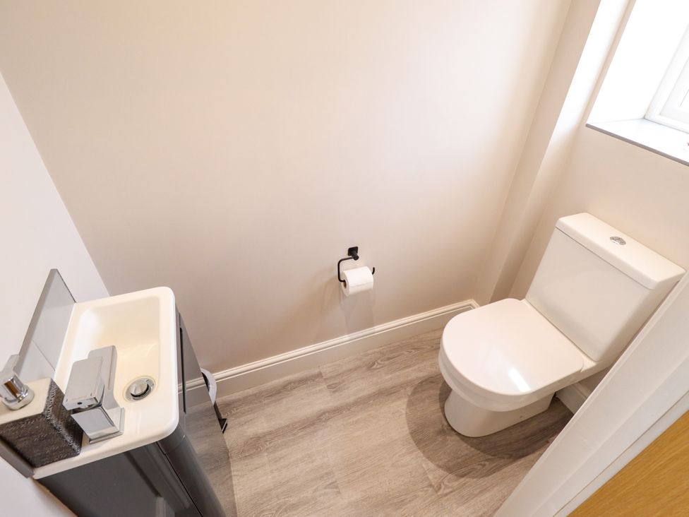 A bathroom with a toilet and washbasin at Acacia Barn in Wrangle near Friskney