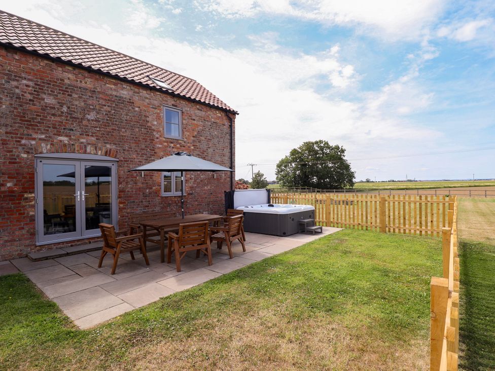 An outdoor patio area with a table and chairs at Acacia Barn Wrangle near Friskney
