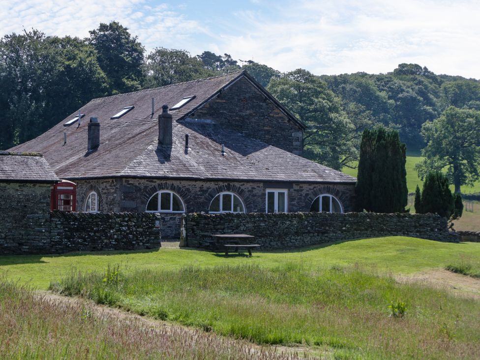 A building with a stone wall and picnic table at Windermere at the Graythwaite Estate near Hawkshead