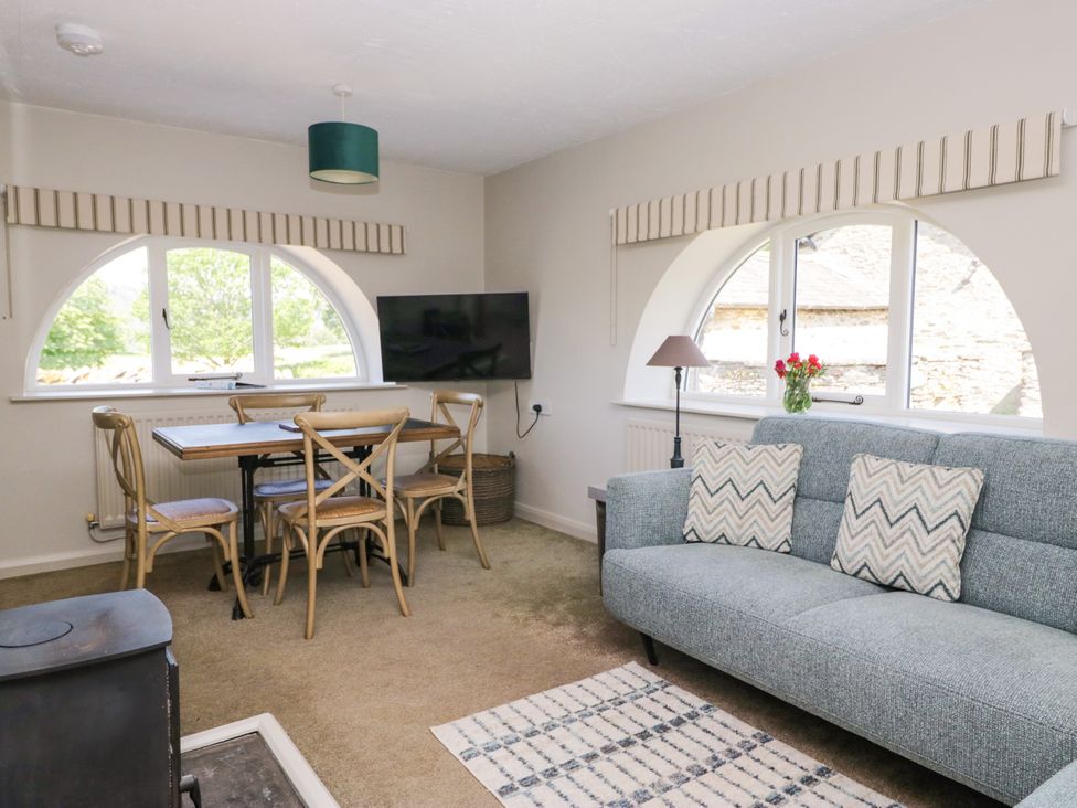 A living room with a dining table and sofa at Windermere at the Graythwaite Estate near Hawkshead