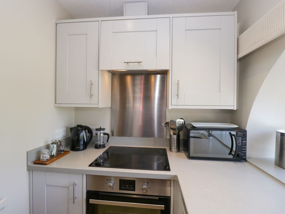 A kitchen with a cooktop and microwave at Windermere at the Graythwaite Estate near Hawkshead