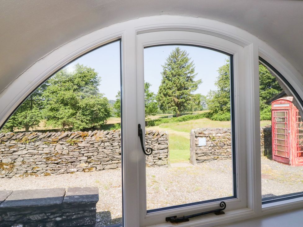 A view through a window showing a stone wall and a telephone box at Windermere at the Graythwaite Estate near Hawkshead