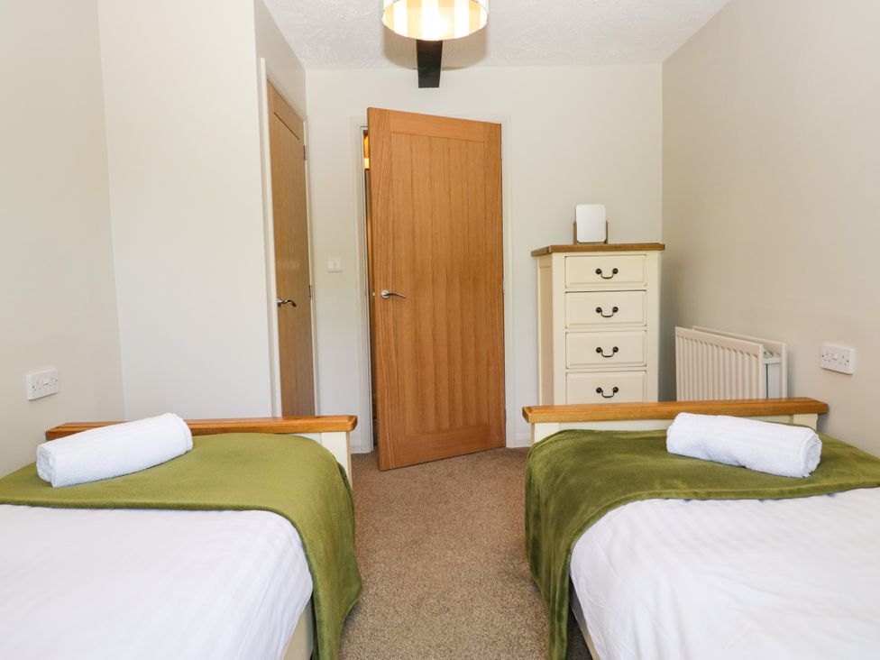 A bedroom with two single beds and a dresser at Windermere at the Graythwaite Estate near Hawkshead