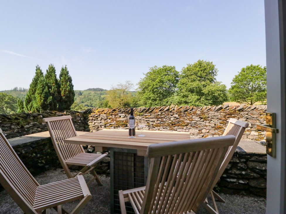 An outdoor seating area with a table and chairs at Windermere at the Graythwaite Estate near Hawkshead