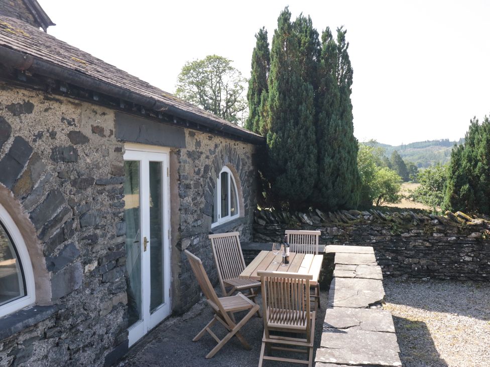 An outdoor seating area with a table and chairs at Windermere at the Graythwaite Estate near Hawkshead