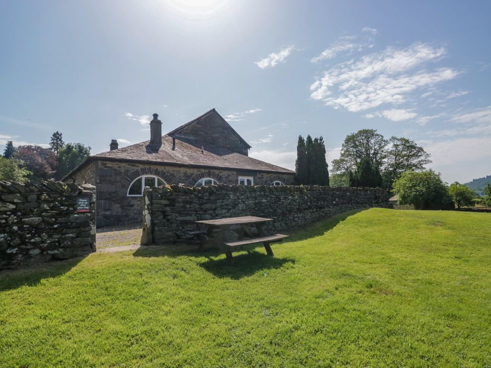 An outdoor area with a stone building and a picnic table at Windermere at the Graythwaite Estate near Hawkshead