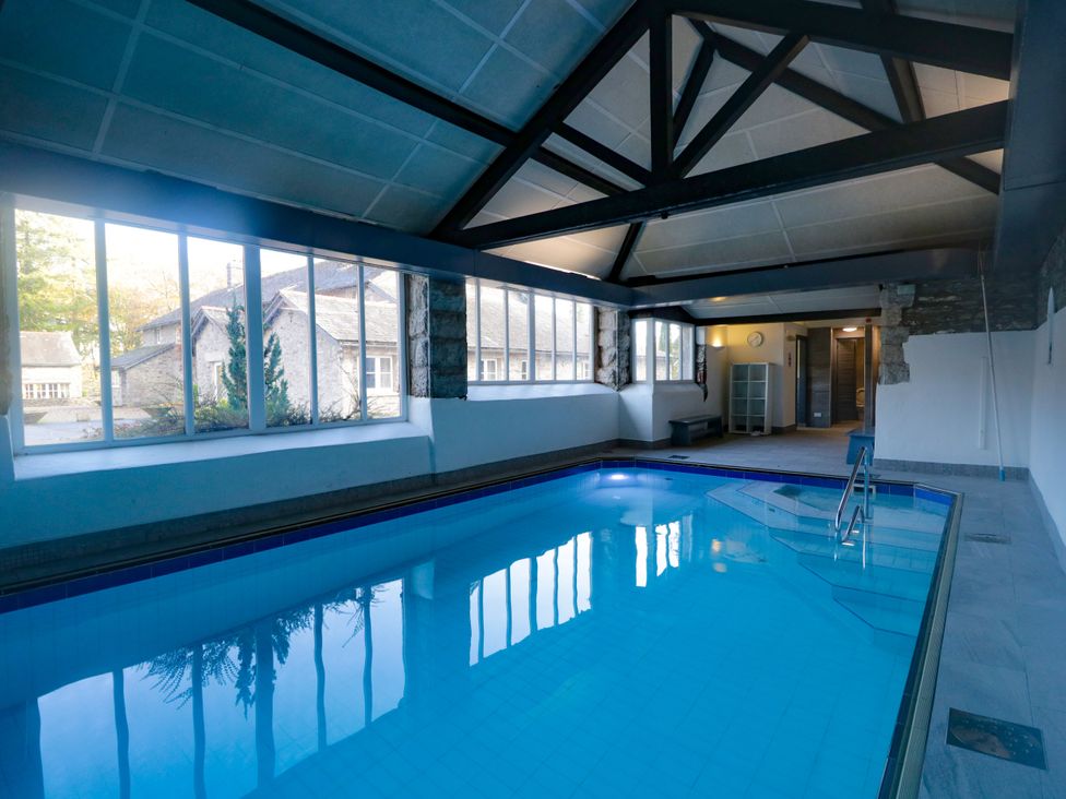 An indoor pool with large windows and seating at Briar in Graythwaite near Hawkshead