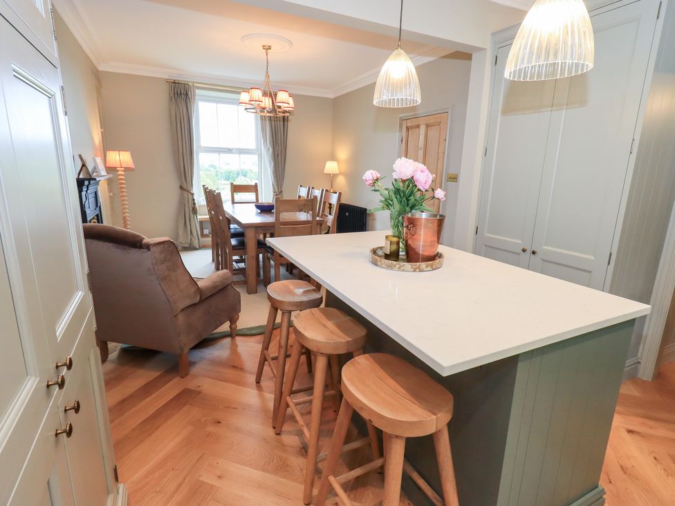 A kitchen with a dining area and bar stools at High Torver House in Torver