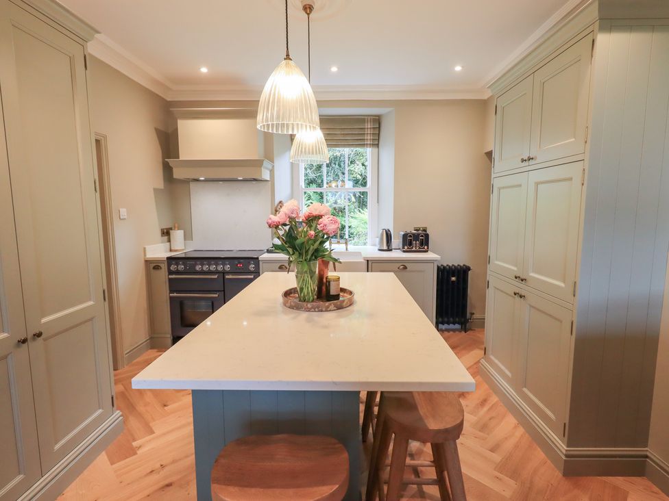 A kitchen with an island and kitchen appliances at High Torver House in Torver