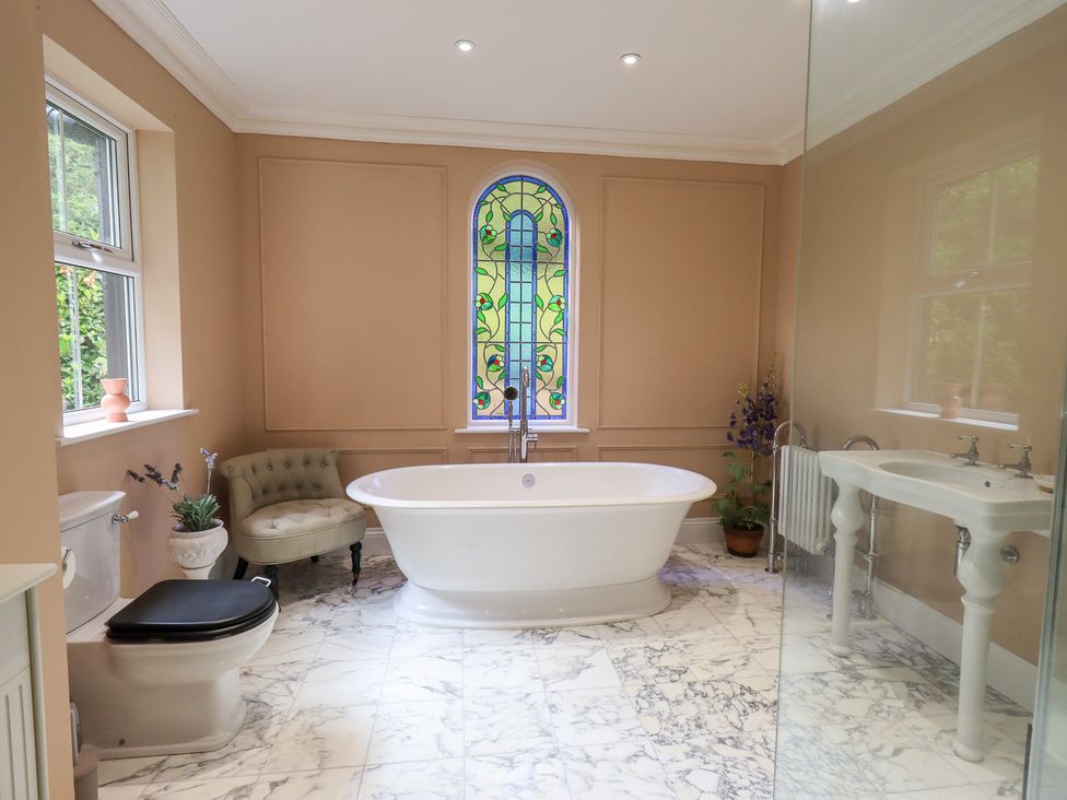 A bathroom with a bathtub and sink at High Torver House in Torver