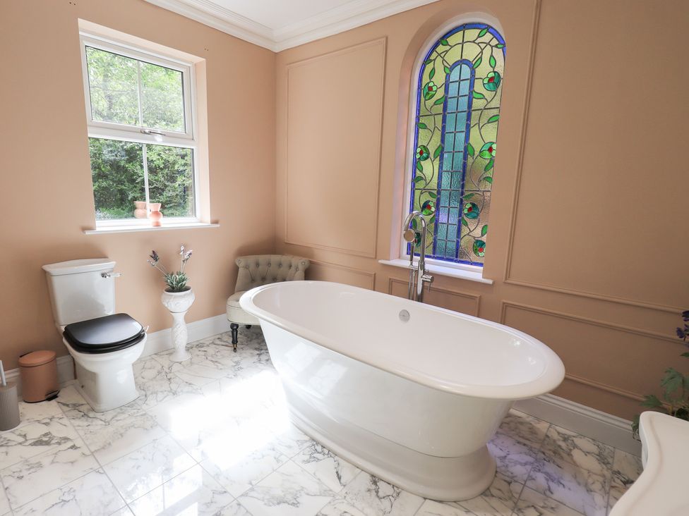 A bathroom with a bathtub and toilet at High Torver House in Torver