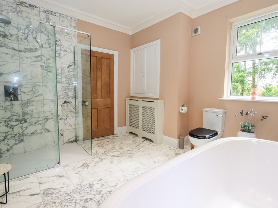 A bathroom with a shower and bathtub at High Torver House in Torver
