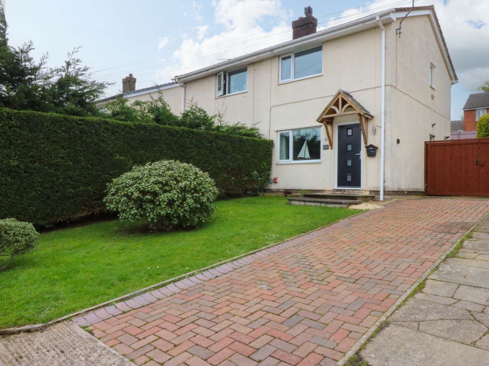 A house with a pathway and hedges at Pebbles Reach Colwyn Bay