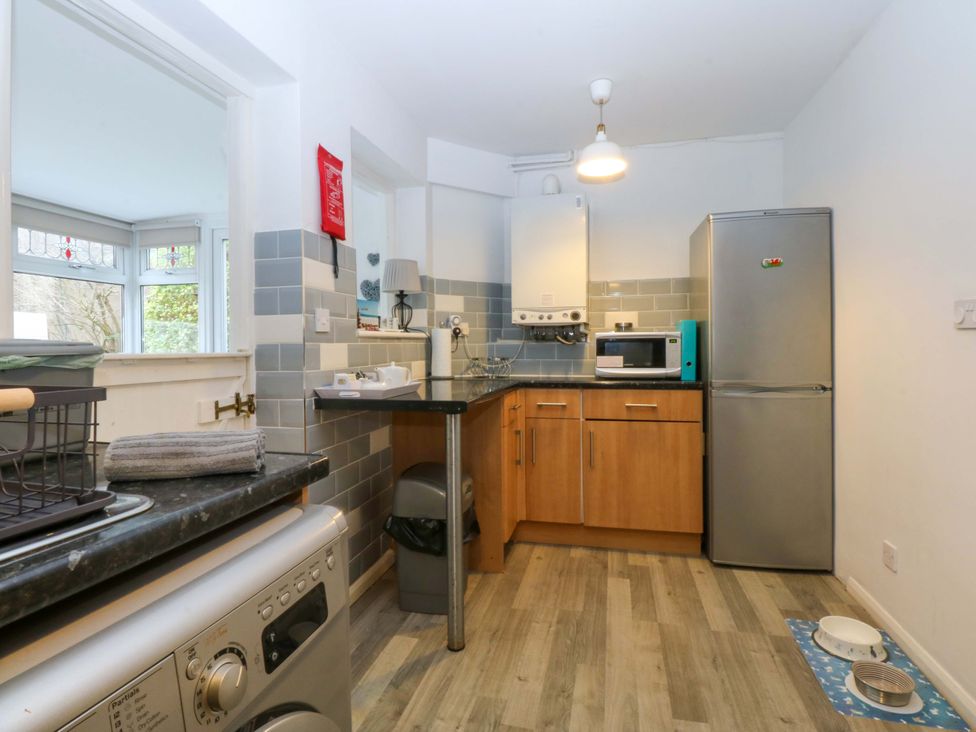A kitchen with a refrigerator and microwave at Pebbles Reach in Colwyn Bay