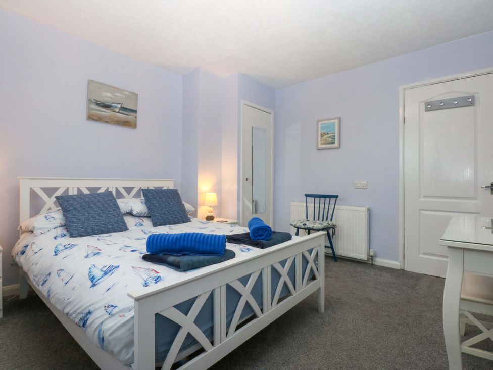 A bedroom with a bed and chair at Pebbles Reach in Colwyn Bay