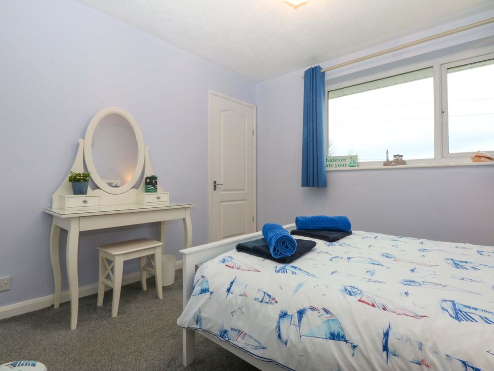 A bedroom with a bed and vanity at Pebbles Reach in Colwyn Bay
