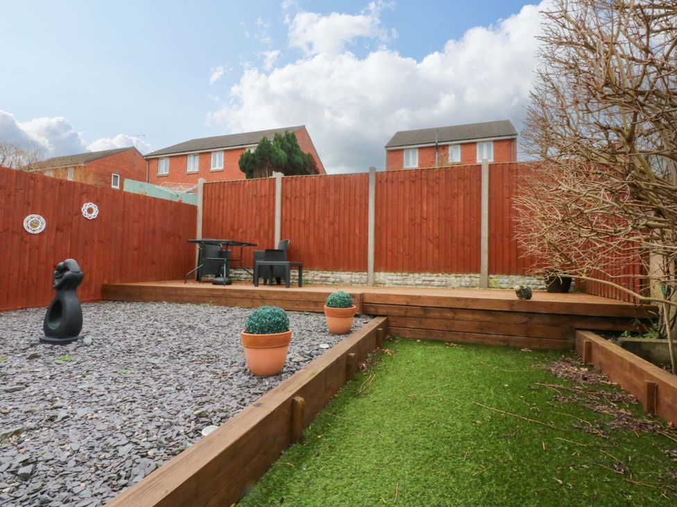 A garden with a table and chairs at Pebbles Reach in Colwyn Bay