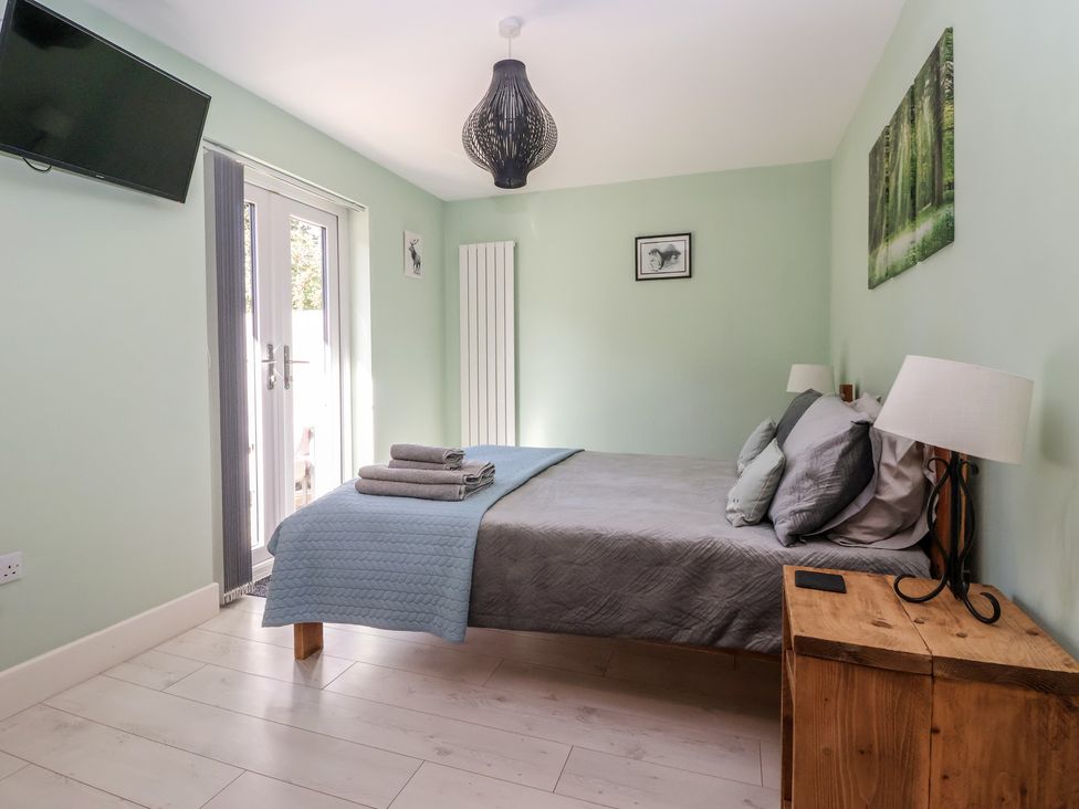 A bedroom with a bed and a TV at Bluebell Wood in Brandesburton