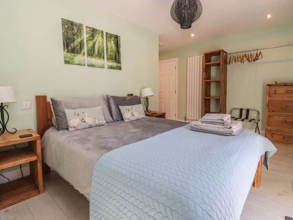 A bedroom with a bed, nightstand, and chest of drawers at Bluebell Wood in Brandesburton