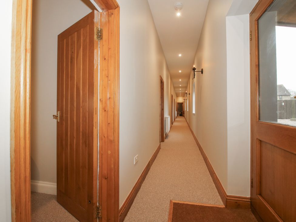 A hallway with doors and light fixtures at The Park in Ludlow
