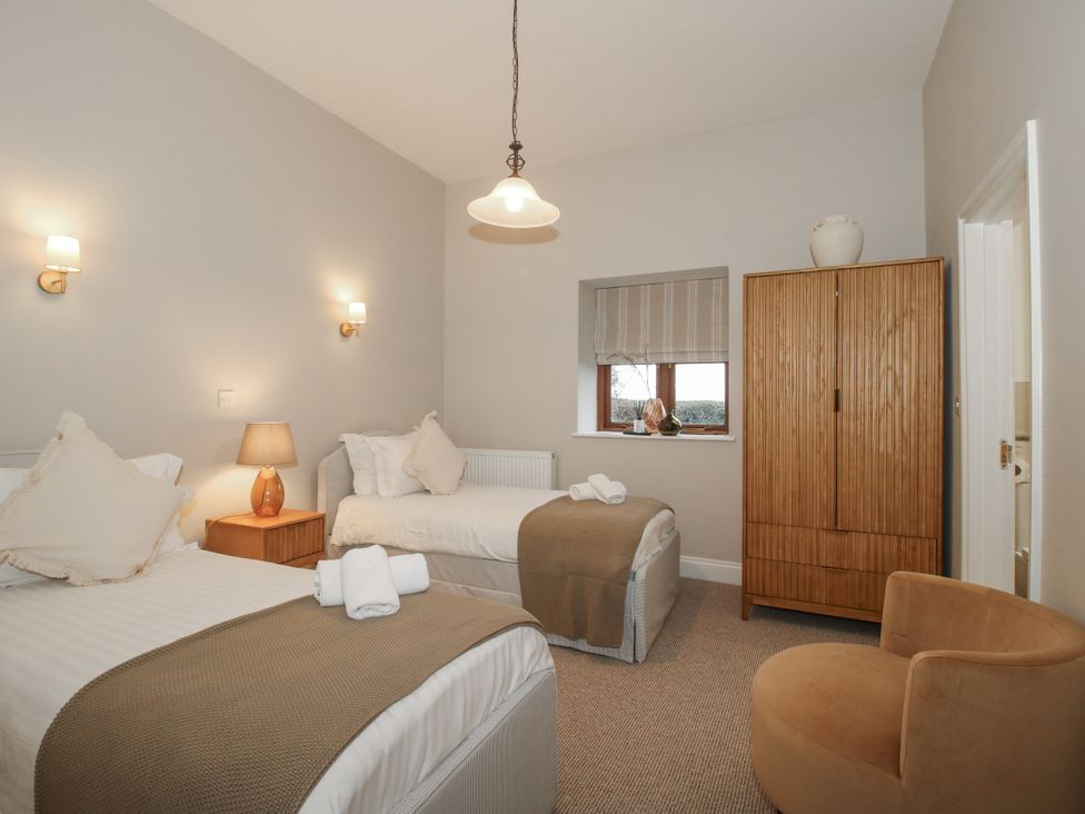 A bedroom with two beds and a wardrobe at The Park in Ludlow