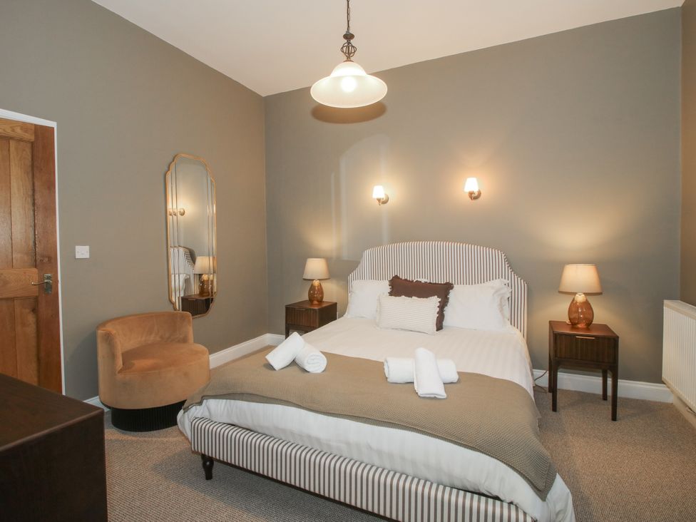 A bedroom with a bed, bedside tables, and a chair at The Park in Ludlow