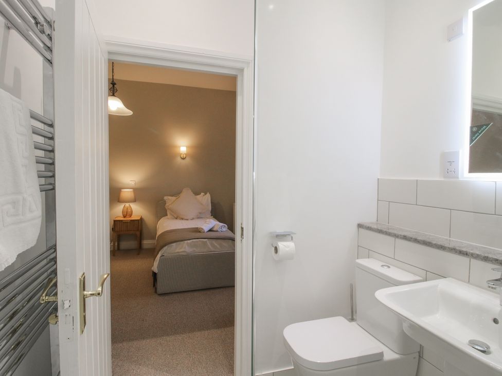 A bathroom with a sink and toilet leading to a bedroom at The Park in Ludlow