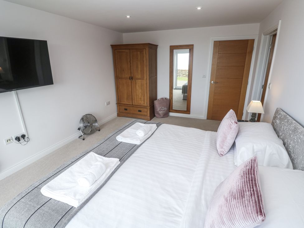 A bedroom with a bed and wardrobe at Atlantic View in Germoe