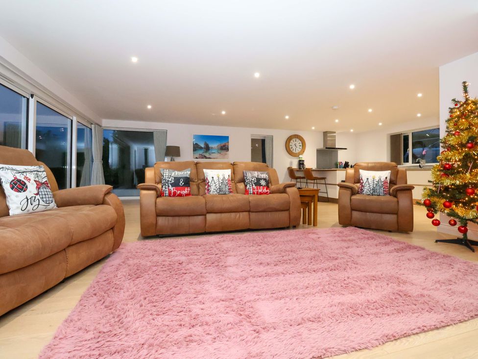 A living room with a sofa and dining table at Atlantic View in Germoe