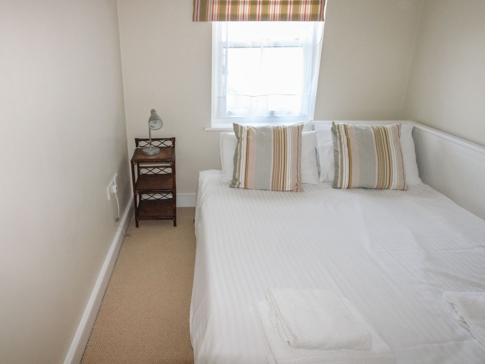 A bedroom with a bed and a bedside table at 4 Thurlestone Beach House in South Milton near Thurlestone