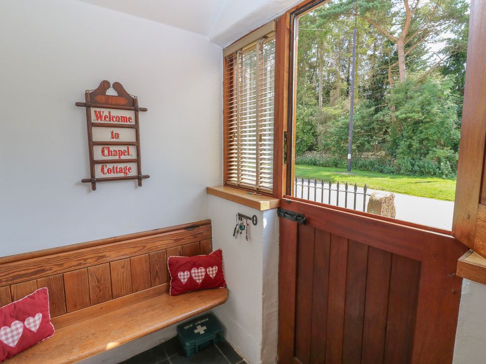 An entrance with a welcome sign and bench at Chapel Cottage in Sandford, Cumbria