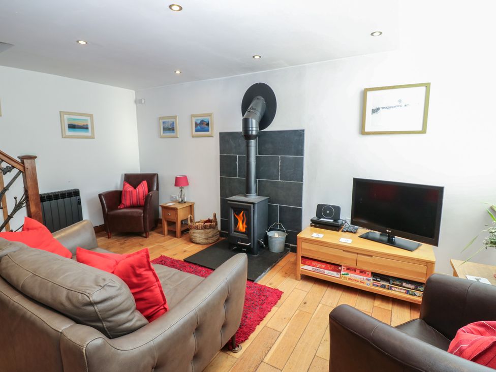 A living room with a fireplace and television at Chapel Cottage in Sandford, Cumbria