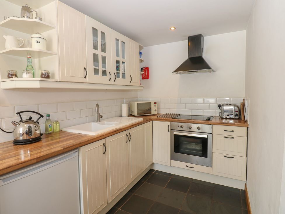 A kitchen with cabinets and appliances at Chapel Cottage in Sandford, Cumbria