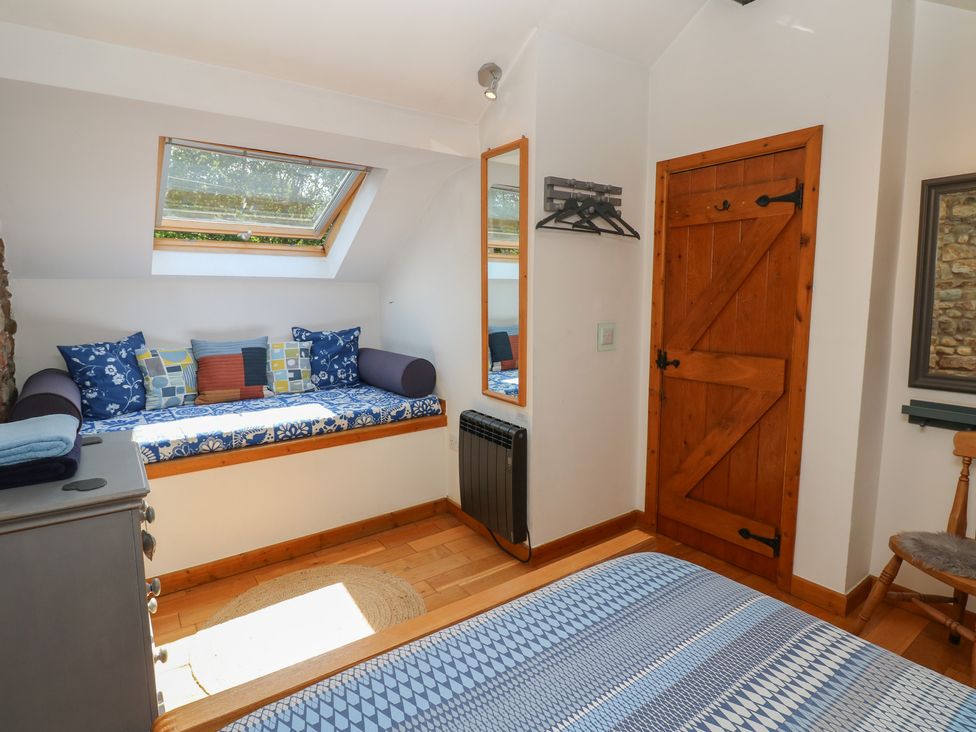 A bedroom with a bed and a seating area at Chapel Cottage in Sandford, Cumbria