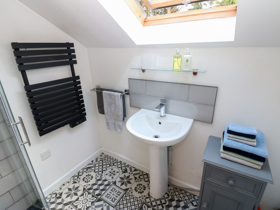 A bathroom with a sink and towel rack at Chapel Cottage in Sandford, Cumbria