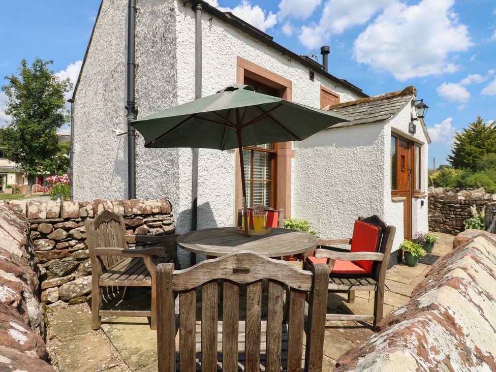 An outdoor seating area with a table and chairs at Chapel Cottage Sandford, Cumbria