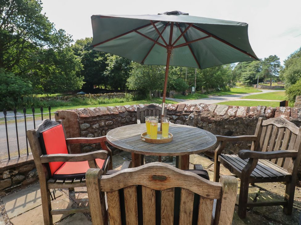 An outdoor seating area with a table and chairs at Chapel Cottage, Sandford, Cumbria
