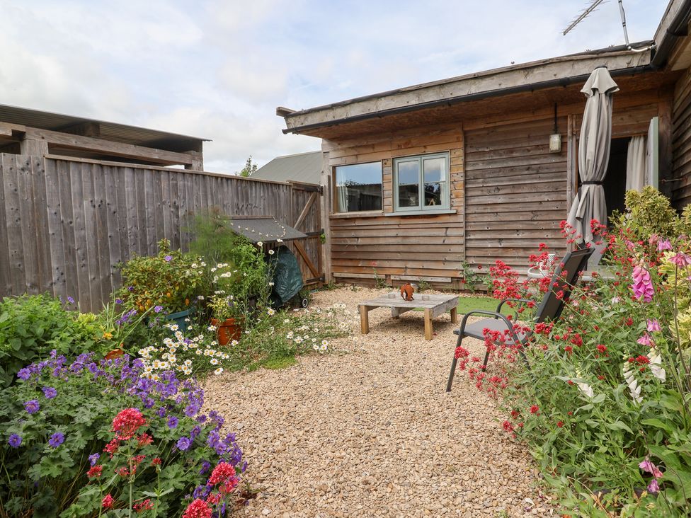 A garden with flowers and furniture at Tiny Willow in Farrington near Child Okeford