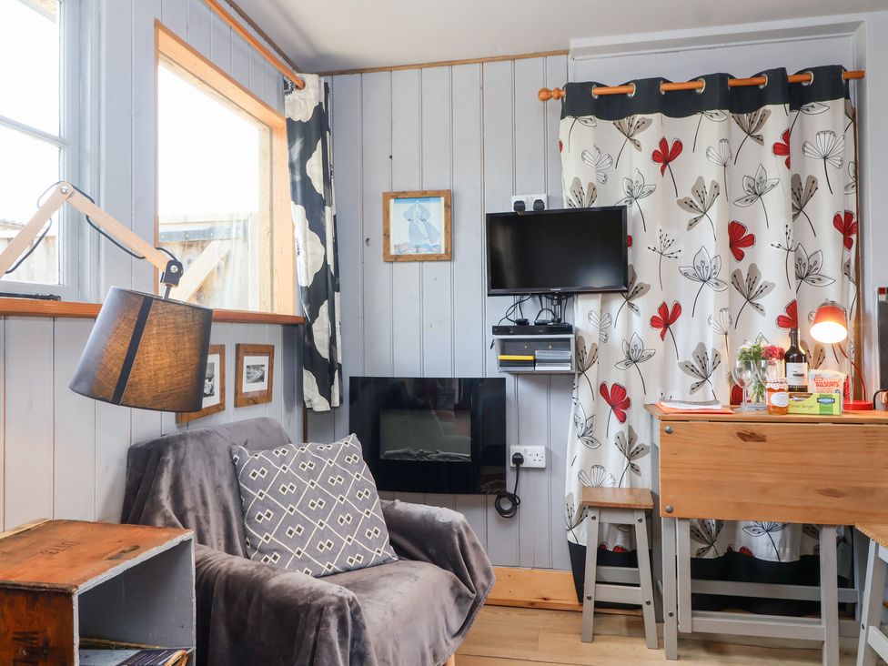 A snug with an armchair and a table at Tiny Willow in Farrington near Child Okeford
