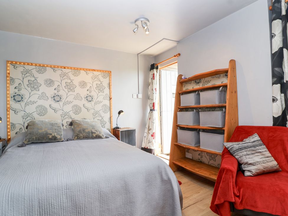 A bedroom with a bed and shelves at Tiny Willow in Farrington near Child Okeford